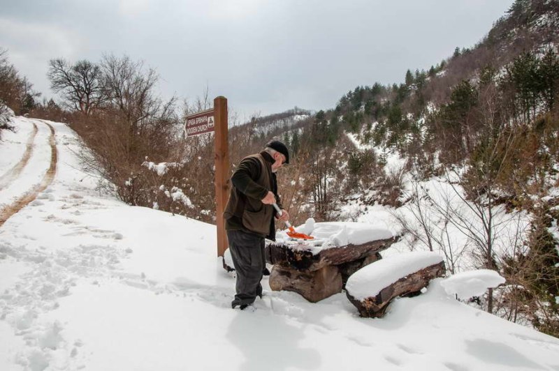Clearing the snow from the table and benches for lunch